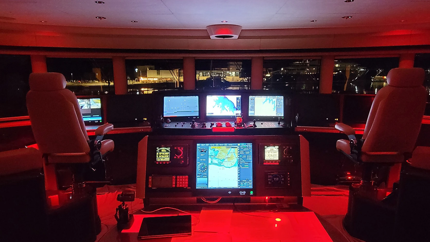 Actual vessel bridge illuminated for nighttime operation with navigation and control displays